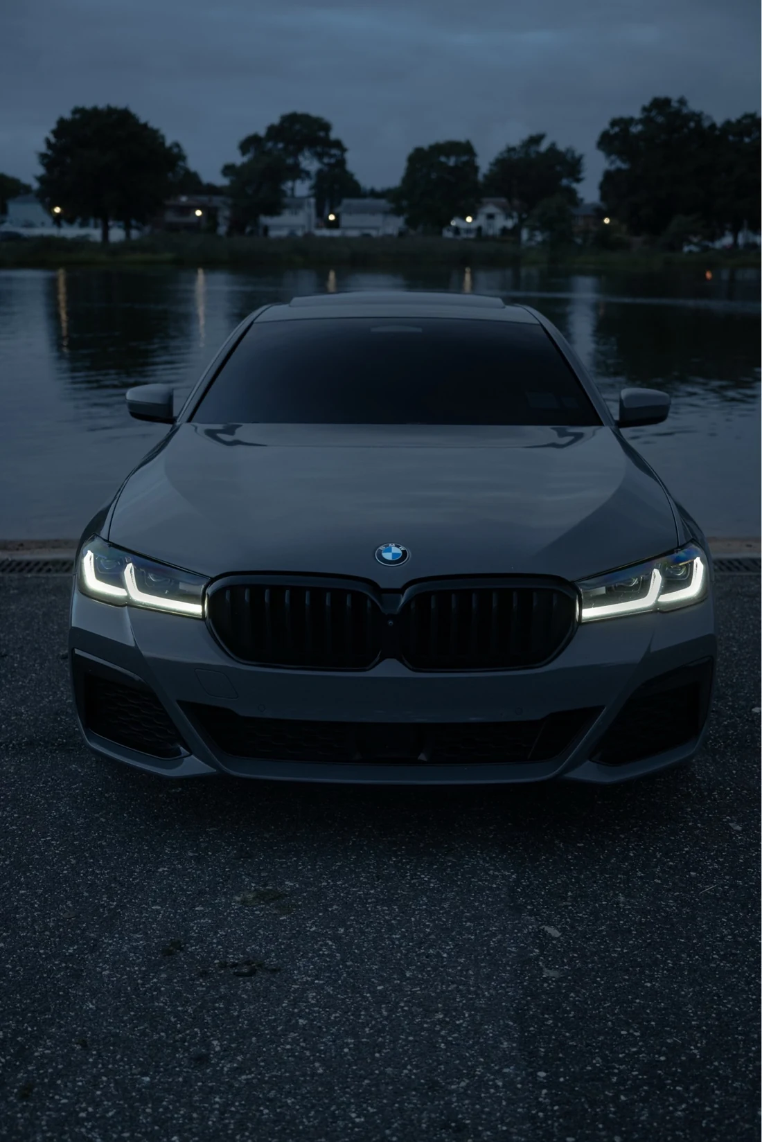 Tinted BMW sedan at dusk by the water showing a dark clean window finish