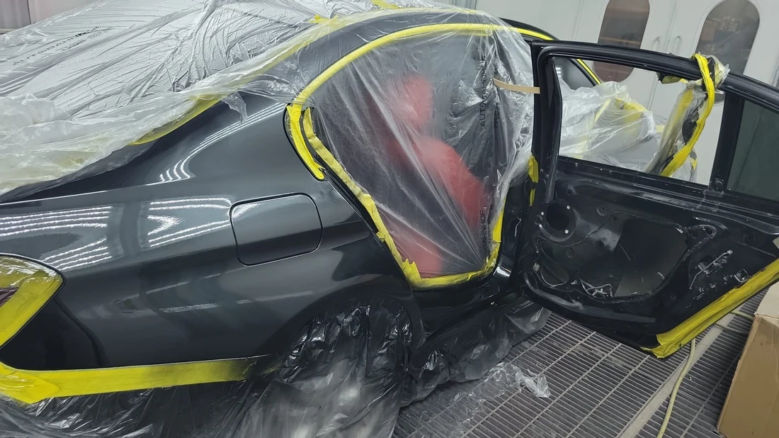 Masked vehicle with red seats prepared for collision and body repair work