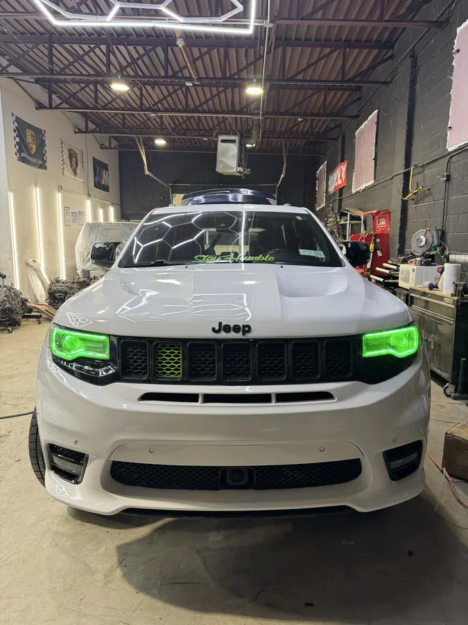 Jeep Trackhawk SUV with green-tinted headlights in the shop